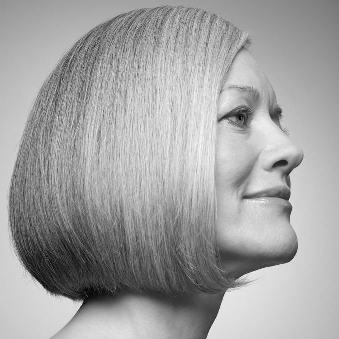 Frau mit schulterlangem, blonden Haar im Profil, freundlich lächelnd.