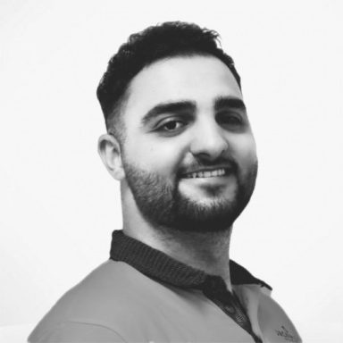 Hassan Junger Mann mit kurzer, dunkler Haarfrisur, lächelt freundlich in schwarzem Shirt.