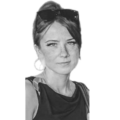 Eine lächelnde Frau mit blonden Haaren und einem blauen Blazer.